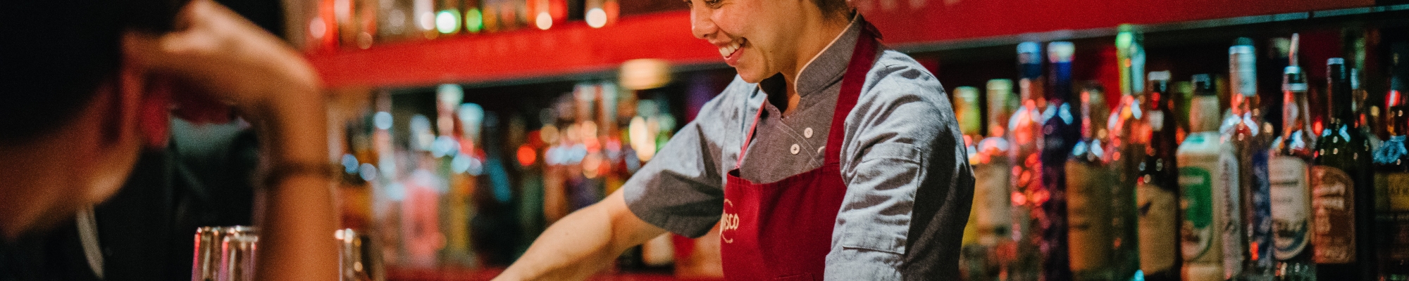 woman bartender smiling while mixing liqueurs 1301547 v2